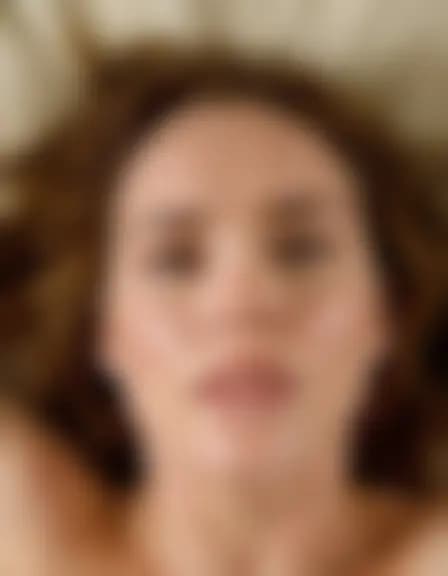 Zoe enjoys a facial cumshot in a messy masculine bedroom.