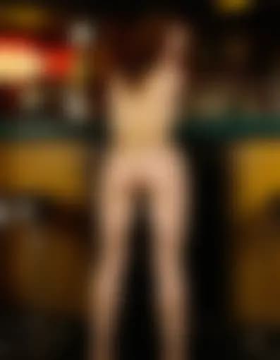 Evelyn, bent over, in a dimly lit bar.